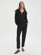 Pantalón negro de tejido DoubleSoft, corte ajustado con puños enrollados, pinzas delanteras y traseras, y bolsillos con forma.