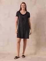 Camisón corto negro con estampado de pequeños círculos blancos, escote redondo con ribete negro, mangas cortas y detalle plisado en el pecho.