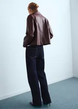 Jeans rectos de tiro medio color azul oscuro, con cinco bolsillos, trabillas para cinturón y cierre frontal con botón y cremallera.