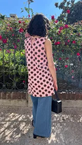 Vestido corto sin mangas, color rosa pálido con estampado de lunares marrones.
