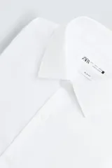 Camisa de corte slim fit con textura, cuello italiano y manga larga con puños abotonados. Presenta cierre frontal con botones.