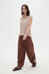 Blusa de poliéster sin mangas con cuello redondo y estampado geométrico en tonos marrones y blancos, de corte holgado y diseño fluido.