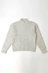 Buzo de punto con diseño de trenzas, cuello alto y textura jaspeada en color beige.