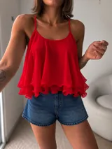 Blusa de tirantes finos en color negro, con diseño fluido de múltiples capas con volados y corte evasé.
