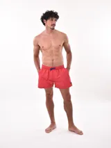 Short de baño color lila con estampado de palmeras blancas, cuenta con cintura elástica con cordón ajustable y bolsillos laterales.