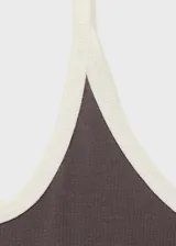 Musculosa gris con tirantes finos blancos y cuello redondo con ribete blanco.