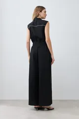 Mono negro de lino con corte recto, cuello camisero, sin mangas y vivo blanco en contraste en cuello, sisas y laterales.