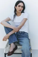 Jeans de tiro alto con corte recto y largo completo. Presenta diseño de cinco bolsillos, trabillas en la cintura y cierre frontal con cremallera y botón, con un acabado de efecto lavado.