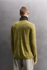 Camiseta térmica de manga larga ranglán, cuello redondo, color verde oliva con efecto tie-dye o jaspeado. Presenta tejido con lana, alta elasticidad y ajuste al cuerpo, con estructuras combinadas para facilitar la transpiración y sin costuras.
