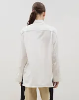 Camisa de corte holgado y diseño clásico, confeccionada en tela satinada con un sutil estampado floral tono sobre tono. Presenta cuello camisero, cierre frontal con botones y mangas largas con puños rectos.