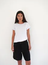 Bermuda negra de tiro medio, corte ancho, con bolsillos laterales y un ojal en la parte trasera.