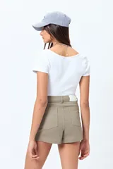 Short blanco de algodón con elastano, calce medio, bolsillos funcionales y tajos pequeños en el ruedo.