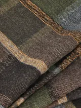 Bufanda de estilo clásico con estampado de cuadros en tonos tierra, verde militar y gris. Confeccionada en tejido suave y con flecos en los extremos.