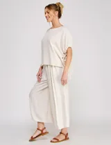 Pantalon palazzo de lino color beige, tiro alto, de silueta amplia y corte ancho con largo tobillero.