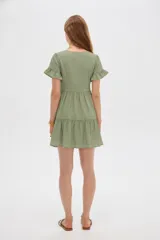 Vestido corto de viscosa color verde, con escote en V, mangas cortas con volados y diseño escalonado en la falda.