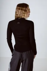 Top negro de tejido de punto con cuello alto y mangas largas.