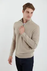Sweater verde oliva de tejido acrílico con textura similar al cashmere, corte clásico, cuello alto con cierre metálico y tirador de cuerina ecológica.