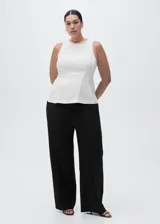 Pantalón de tiro medio color negro, de diseño recto y largo, con trabillas en la cintura, dos bolsillos laterales y cierre oculto con botón, gancho y cremallera.
