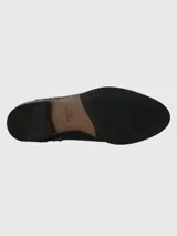 Botín de cuero negro con punta redonda y tacón bajo. Presenta detalle de tachas metálicas plateadas a lo largo del lateral y panel trasero con textura efecto reptil. Cuenta con elástico lateral para facilitar el calce.