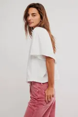 Remera de jersey de algodón blanca con silueta murciélago, escote barco y mangas dolman muy anchas de corte recto y holgado.