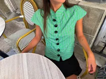 Top verde a cuadros con patrón de rayas y líneas azules y blancas, diseño entallado con mangas cortas abanicadas, cuello mao y cierre frontal con grandes botones negros esféricos.