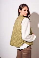 Chaleco verde militar con diseño acolchado y cierre frontal con botones.