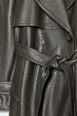 Trench coat de Zara con efecto piel texturizada en color gris oscuro. Presenta cuello con solapas, cierre frontal cruzado con botones, cinturón lazada del mismo material, mangas largas con trabillas y abertura en la espalda.