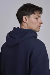 Buzo hoodie azul marino de algodón con corte holgado, capucha con cordones ajustables, bolsillo tipo canguro y etiqueta con logo en el frente.