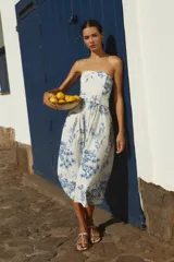 Vestido midi strapless con estampa floral azul sobre fondo blanco, con cinturón.