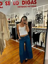 Pantalón jean oxford de tiro medio-alto, ajustado en la cadera con caída amplia y fluida desde la rodilla. Cuenta con cortes verticales y costuras marcadas en las piernas.