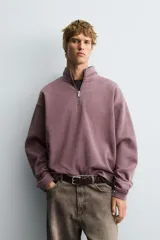 Sudadera de corte boxy fit con cuello subido y cierre frontal de cremallera. Presenta mangas largas, acabado efecto lavado y puños y ruedo en rib.