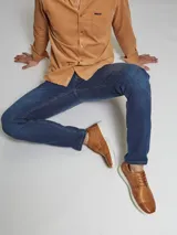 Zapato acordonado de cuero color marrón con suela blanca de PVC.