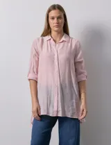 Camisa larga de rayón, con cuello clásico, cierre frontal con botones y mangas regulables con presilla. Presenta un diseño holgado con tajos laterales en el ruedo.