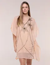 Vestido estilo túnica de dos piezas, color salmón, compuesto por un sobrevestido holgado de gasa semitranslúcida con mangas kimono y escote en V con bordados brillantes de piedras y cuentas, y un vestido base interior tipo enagua de tirantes finos.