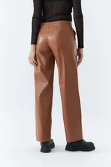 Pantalón marrón de cuero sintético, tiro medio, corte recto cropped y detalle de costuras verticales.