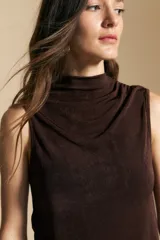 Top sin mangas de color negro con cuello alto y diseño drapeado en el frente. Confeccionado en una tela suave con acabado levemente satinado y silueta fluida.