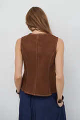 Chaleco de gamuza color caramelo, con cierre frontal de botones y bolsillos laterales simulados.