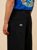Jean de corte baggy fit en denim color azul claro, con diseño de cinco bolsillos y cierre frontal con botón metálico.