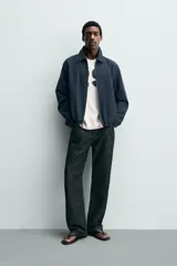 Cazadora boxy fit color azul marino, confeccionada en tejido de algodón. Presenta cuello solapa, manga larga con puño abotonado, bolsillos de vivo en la cadera y bajo elástico. Cierre frontal con cremallera.