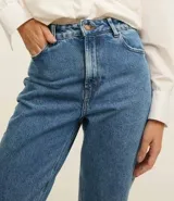 Pantalón mom jean celeste de tiro alto, con bolsillos delanteros y traseros, cierre con cremallera y botón, y ruedo doblado.