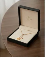 Collar de acero con baño de oro, con diseño de cadena ajustable y dos dijes colgantes: un círculo calado con textura y un aro liso.
