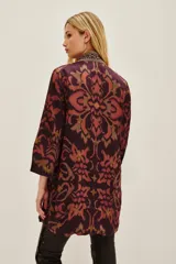 Kimono de viscosa con estampado ikat en tonos bordó y rosado, con bordes decorados con detalles geométricos y mangas tres cuartos.