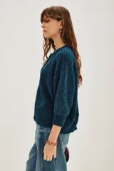 Cardigan de punto grueso acanalado color azul, con cuello redondo, cierre frontal de botones y mangas largas.