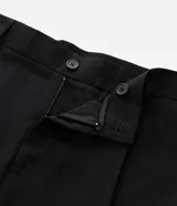 Pantalón de sastrería color negro, de corte recto y fluido. Presenta cintura estructurada con trabillas, cierre frontal con botón y cremallera, pliegues delanteros y bolsillos laterales funcionales.