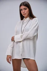 Camisa de manga larga color beige, con cuello clásico y botones frontales.