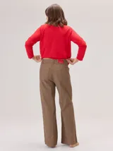 Pantalon de corte recto con costuras verticales decorativas en contraste color rojo. Presenta cintura con trabillas, cierre frontal con botón y bolsillos laterales.