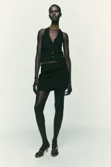 Falda pantalón negra de tiro alto con diseño cruzado y pliegues drapeados en el frente.