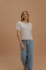 Remera de algodón color crema con mangas globo de popelina bordada con diseño calado. Presenta cuello redondo, corte recto y ajuste cómodo.