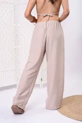 Pantalón palazzo de lino color beige, de tiro medio-alto, con cintura elastizada y silueta holgada de caída fluida.