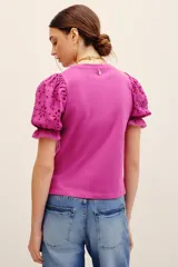 Remera fucsia con mangas abullonadas de broderie estilo globo, con cuello redondo y diseño liso en el cuerpo.